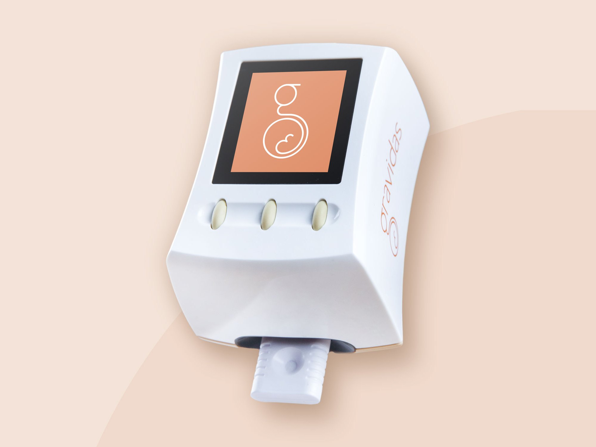 The Gravidas testing device with the g logo on its screen, on a peach background